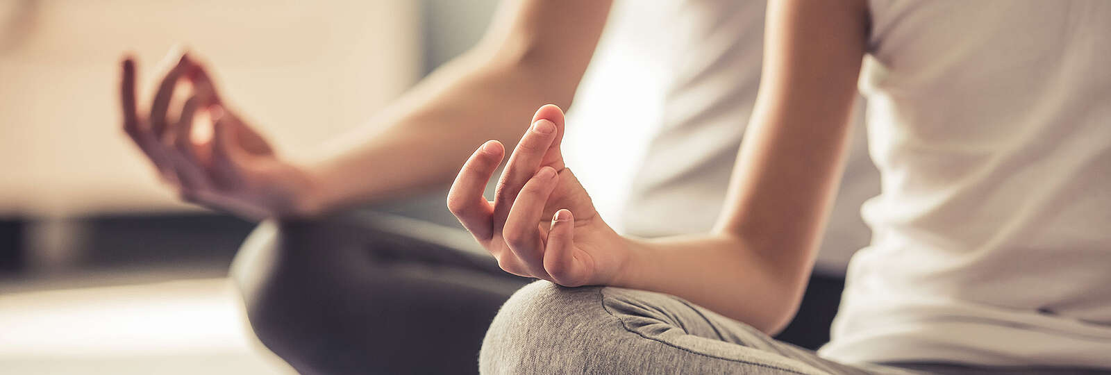 2 Menschen meditieren im Schneidersitz