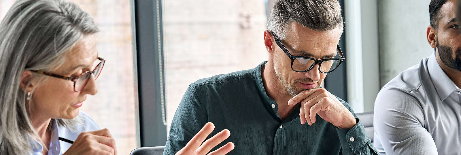 Eine ältere Frau erklärt ihrem Team etwas